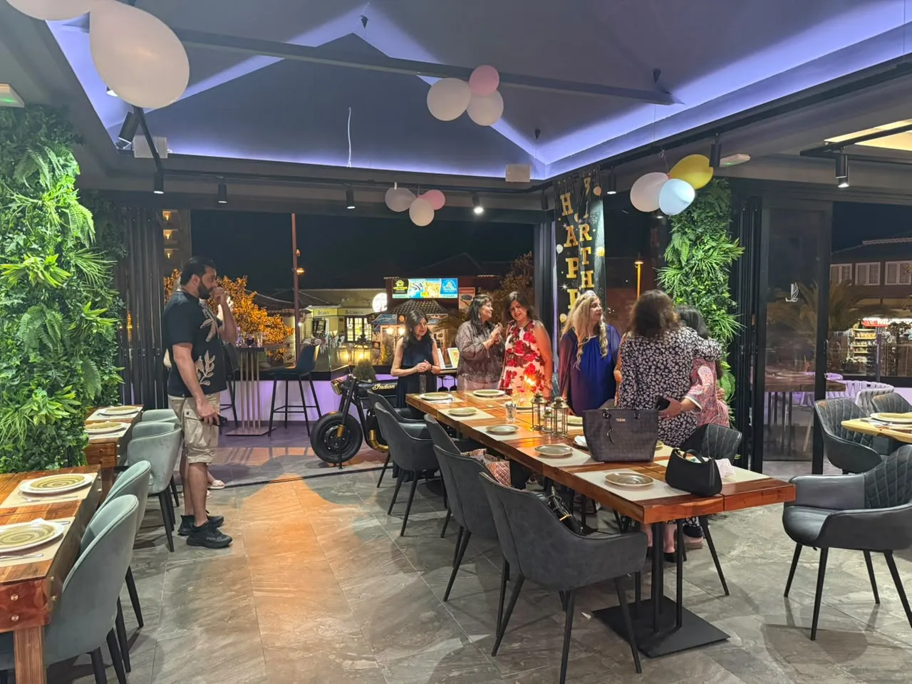 Guests gathered around a dining table with birthday balloons at Monsoon Tenerife